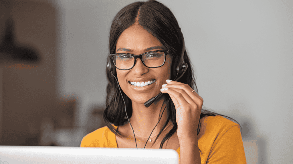 Customer support representative with headset smiling, delivering international 24/7 support in multiple languages.