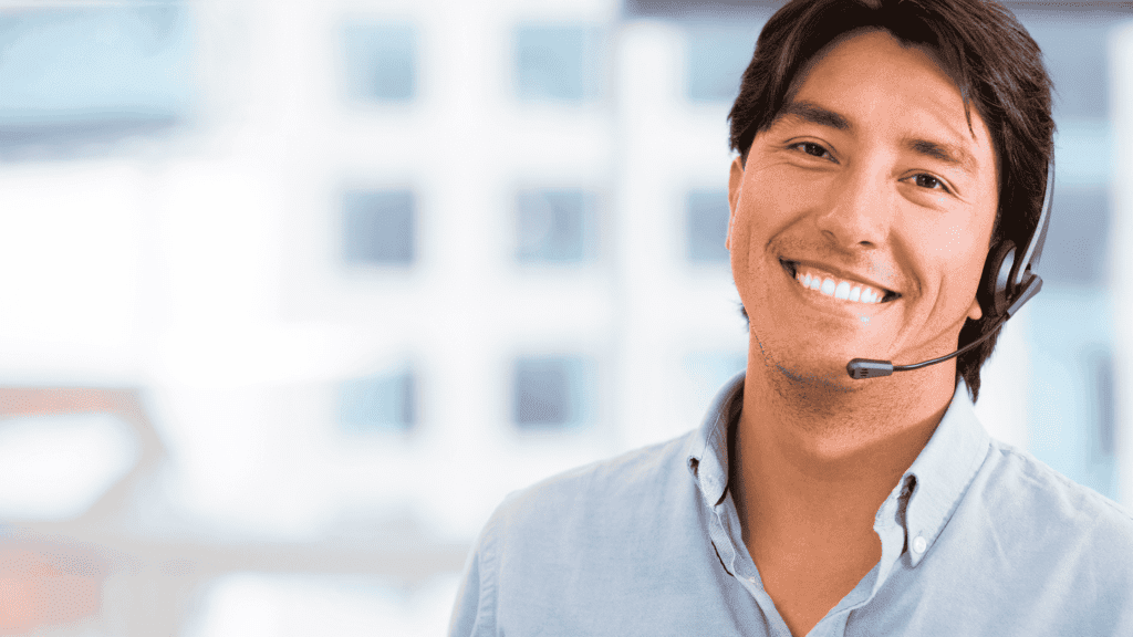 Customer service agent smiling while wearing a headset, representing 24-hour multilingual support hotline services.