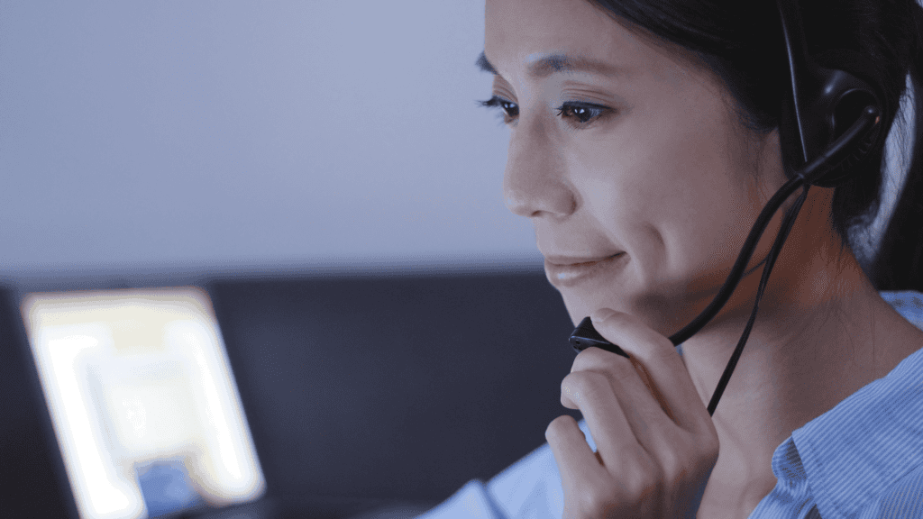 Customer support agent with headset working attentively in a round-the-clock multilingual call centre.