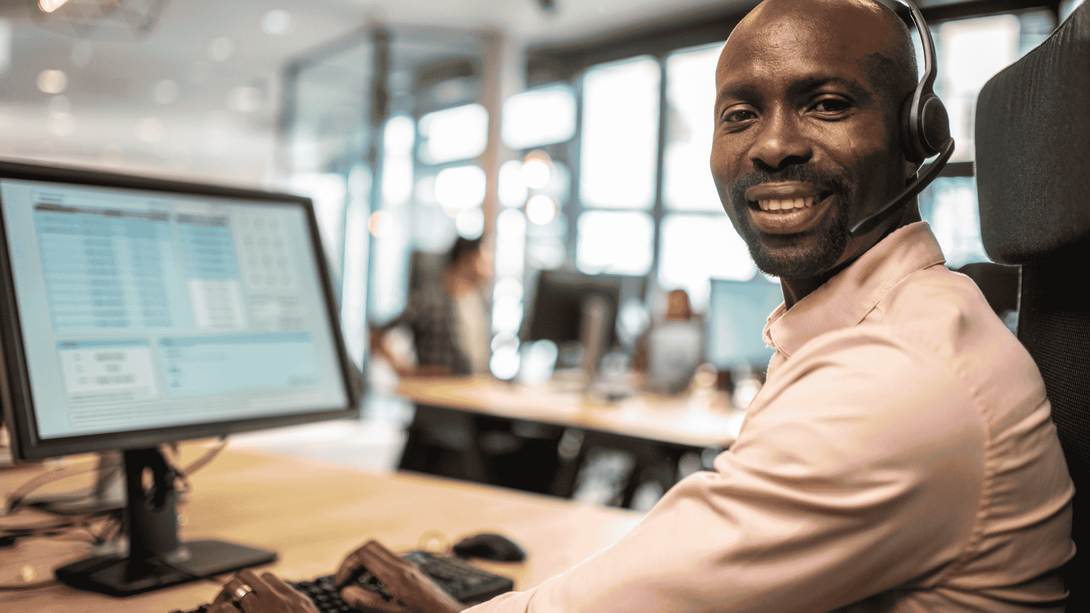 Customer support agent smiling with headset, symbolising international 24/7 support in languages.