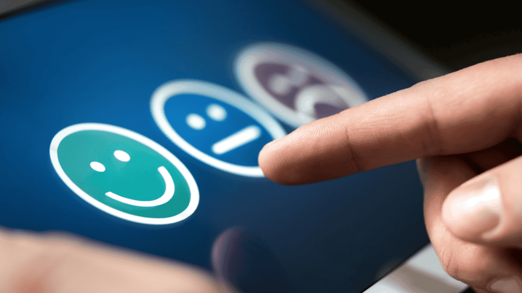 A finger selecting a happy face icon representing customer satisfaction in 24-hour live language support.