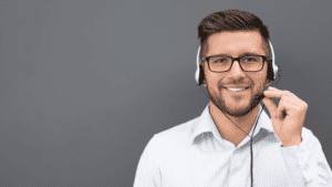 A smiling male customer service agent wearing a headset, ready to assist customers
