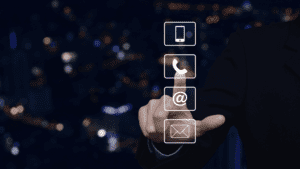 A hand selecting a communication icon (phone, email, and mobile) in a modern digital interface against a cityscape background