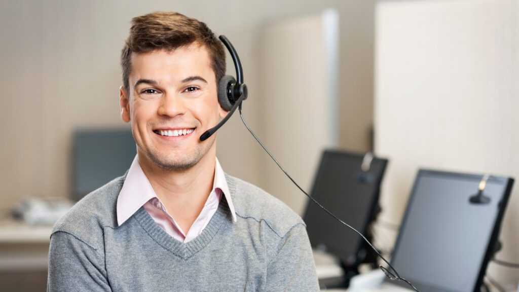 A smiling technical support specialist offering nonstop multilingual technical support from a state-of-the-art office.