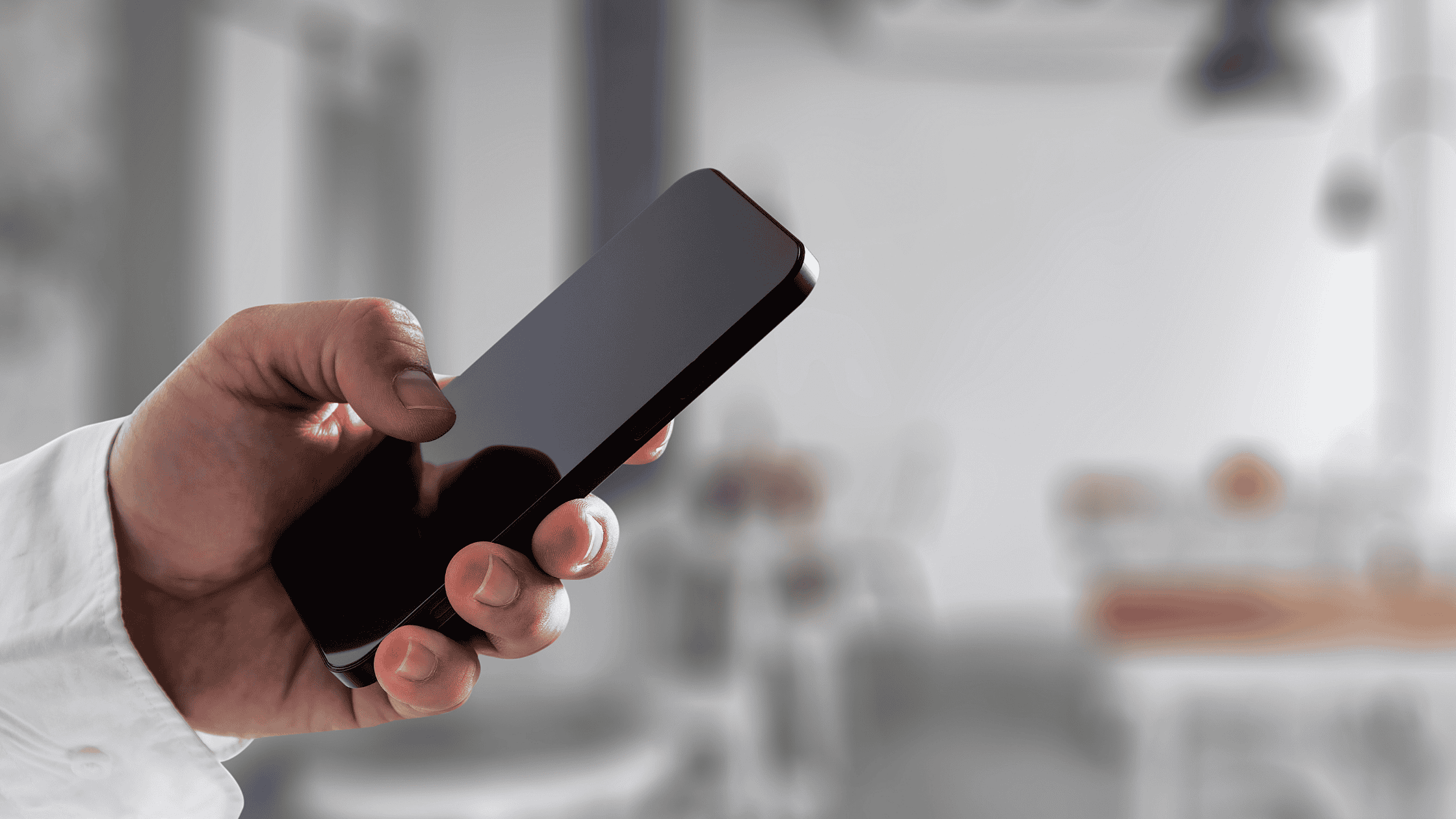 A close-up of a hand holding a smartphone, symbolising accessibility to a multilingual customer care hotline.