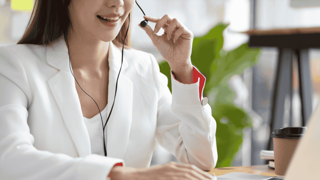 Smiling virtual assistant in a white blazer using a headset for customer support.