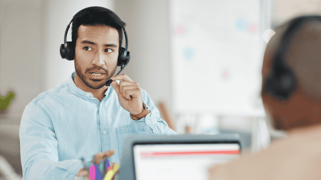 A customer support representative wearing a headset, actively engaging in a conversation while assisting a client.