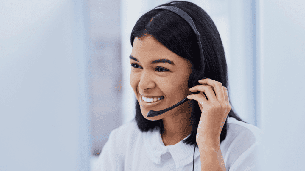 A smiling customer service agent with a headset, delivering multilingual IT support.