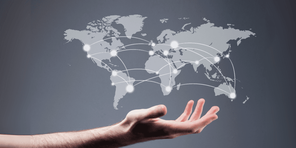 Hand holding a digital world map with glowing connection lines, representing Malta’s strategic location for global customer service and time zone coverage.
