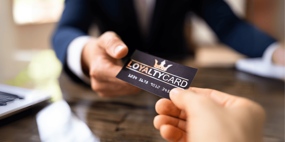Customer receiving a loyalty card from a business representative.